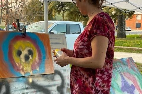 Andrea Chevarria Taylor makes use of the different donated paint colors behind The Clever Tiger Art Studio and Gallery. Photo courtesy Lillian Reyes Gates