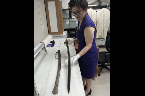 Museum Collections Manager Heather Bloom examines a Civil War-era sword in archives before displaying it in the Bastrop History Museum. Photo courtesy Bastrop County Historical Society